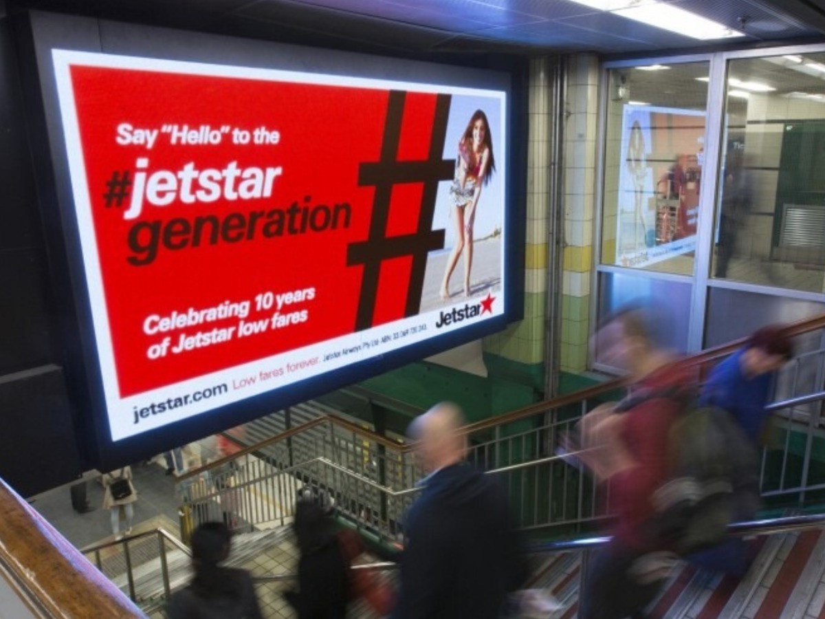 Digital advertising display beside escalators in a transport station